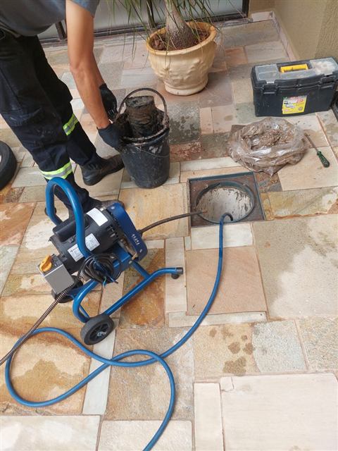 Máquina de desentupimento ligada a uma caixa no piso