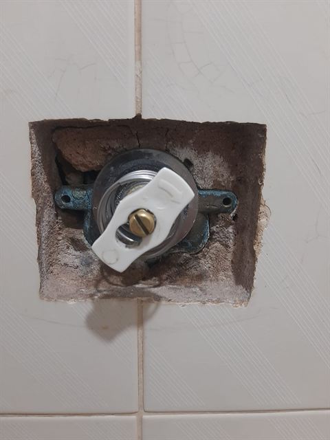 Registro de parede exposto para troca, com abertura pequena no azulejo